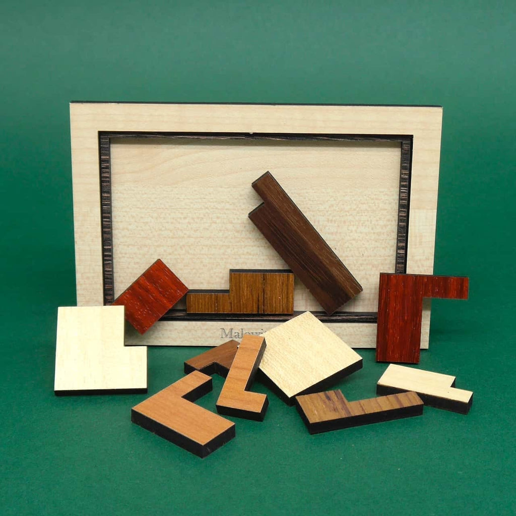 Mehrere farbenfrohe Holzpuzzleteile liegen lose auf einer ebenen Fläche und ergeben zusammengesetzt ein herausforderndes Geduldsspiel.