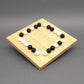 Holzbrettspiel mit schwarzen und weißen Kugeln, die auf einem quadratischen Raster angeordnet sind – perfektes Schiebespiel für strategisches Denken.