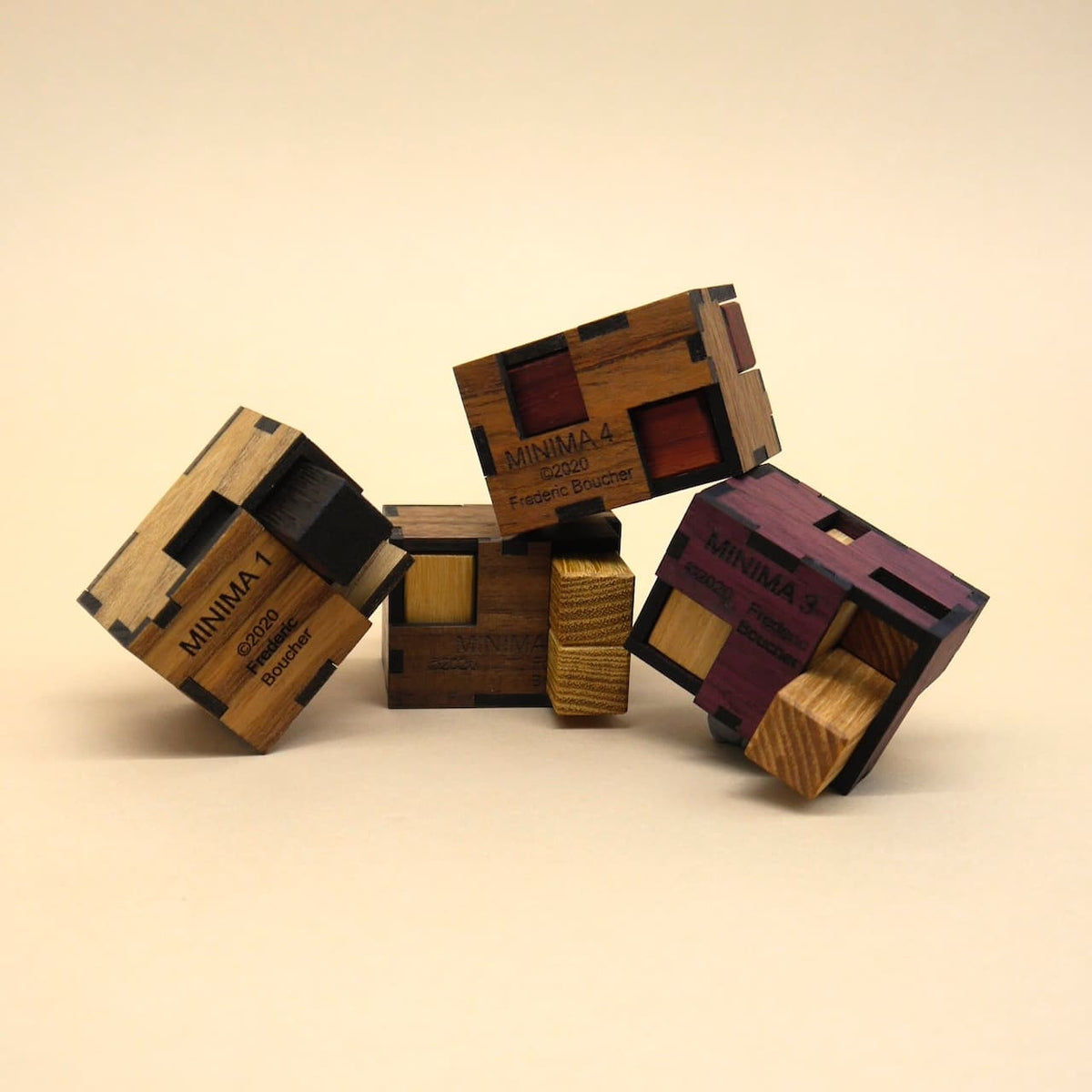 Schräg balancierende MINIMA‑Würfel mit farbigen Einsätzen laden zu anspruchsvollen Geduldsspiele aus edlem Holz ein.