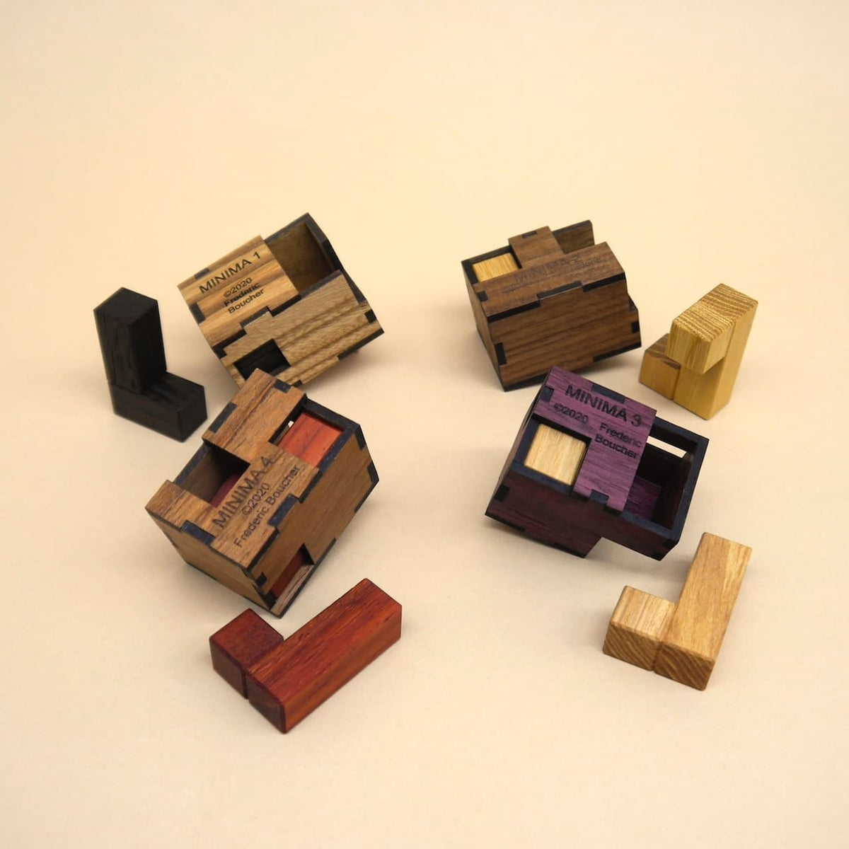Geöffnete MINIMA‑Boxen und ihre Einzelteile zeigen das Innenleben der kniffligen Knobelspiele in dekorativen Holzboxen.