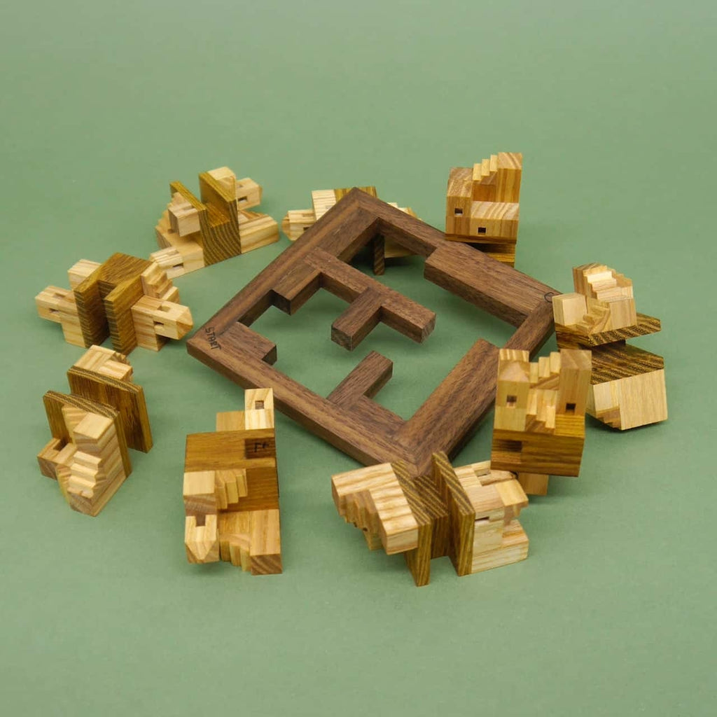 Einzelteile eines Holzpuzzles liegen rund um einen leeren quadratischen Rahmen verteilt, auf grünem Hintergrund.