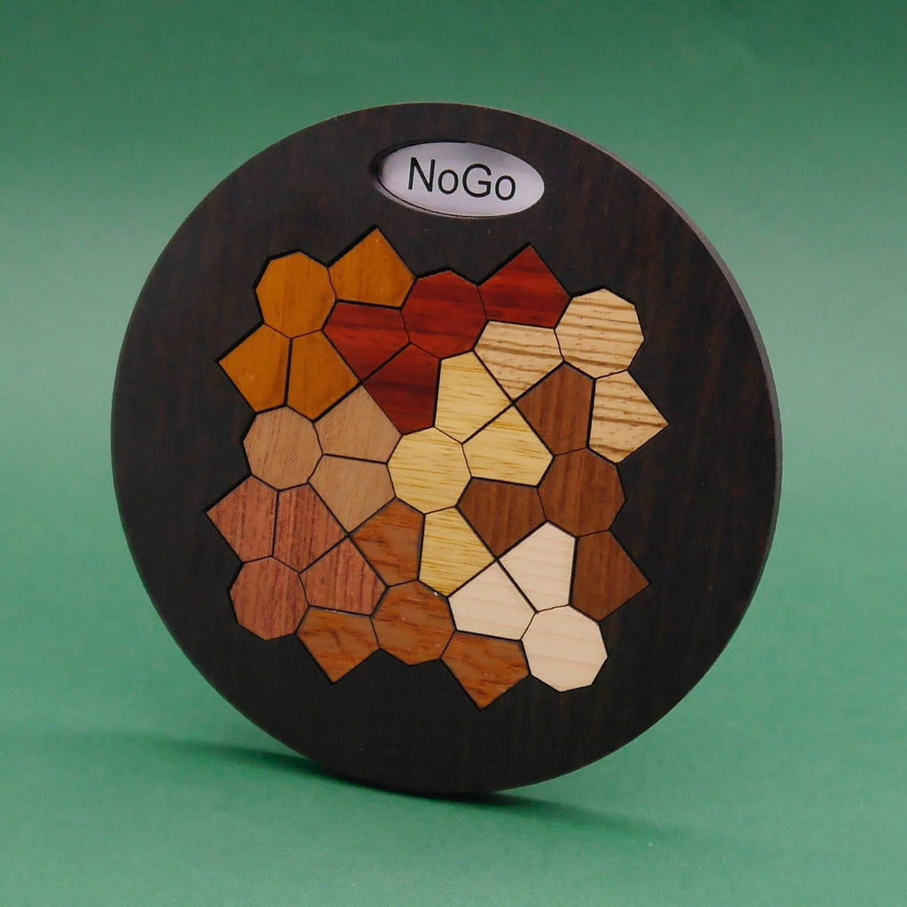 Fertig gelegtes NOGO Legepuzzle aus unterschiedlich gefärbten Holzformen in einem runden Brett.
