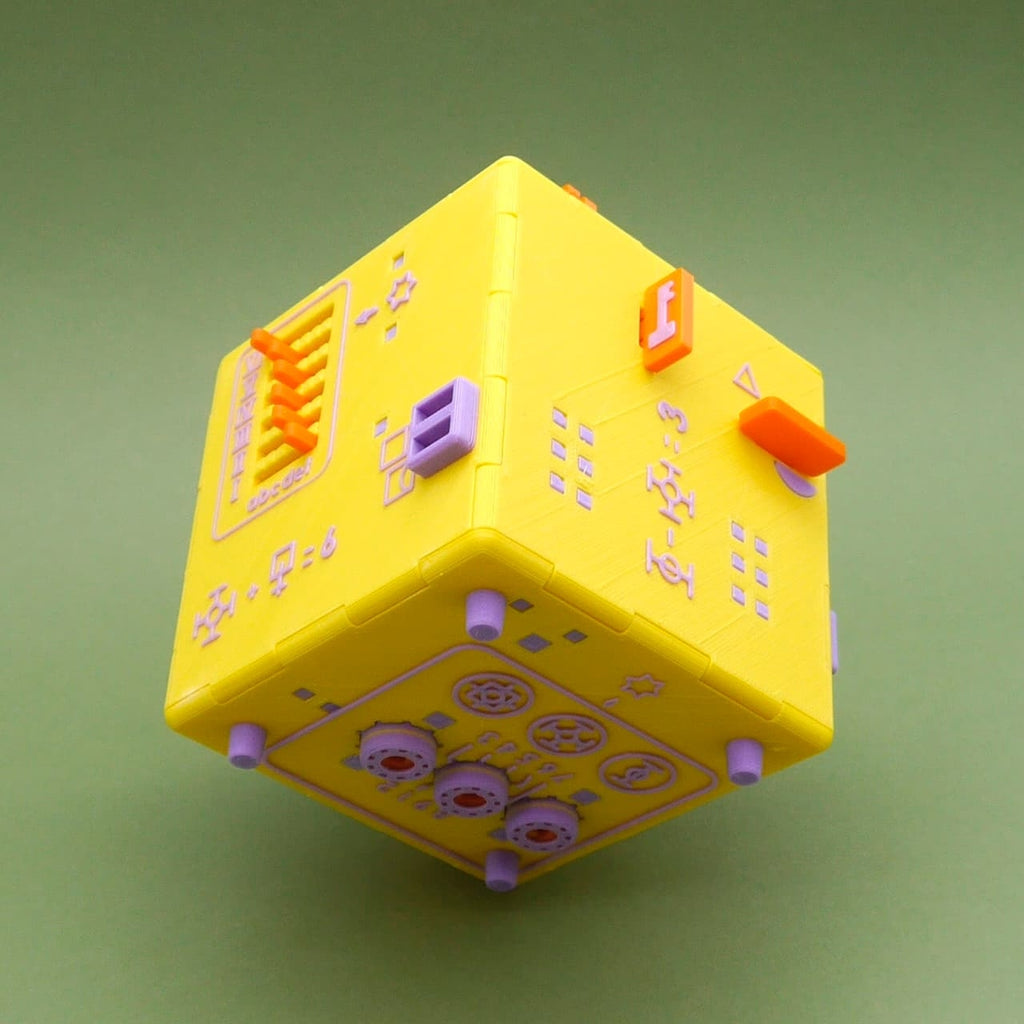 Schwebeaufnahme der gelben Namaste Puzzle Box als Trickbox mit Schiebern, Symbolen und Zahnrädern.