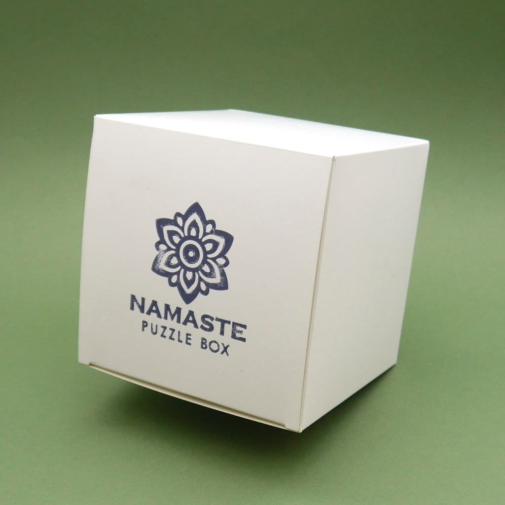 Weiße Verpackung der Namaste Puzzle Box – minimalistisch mit Logo, ideale Geschenkidee.