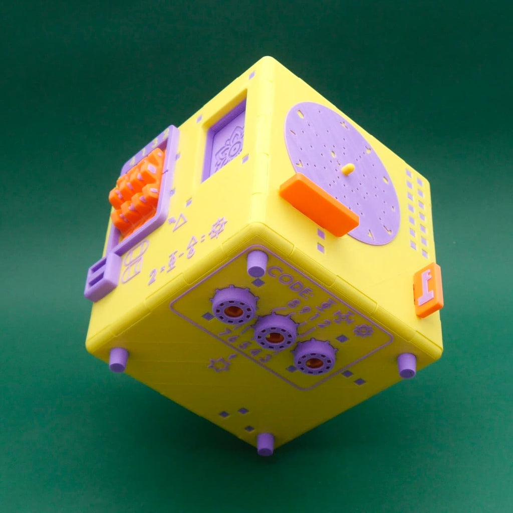 Würfelförmiges Logikpuzzle ‚Namaste Puzzle Box‘ mit runder Lochscheibe, Schiebeplättchen und kleinen Symbolrätseln.