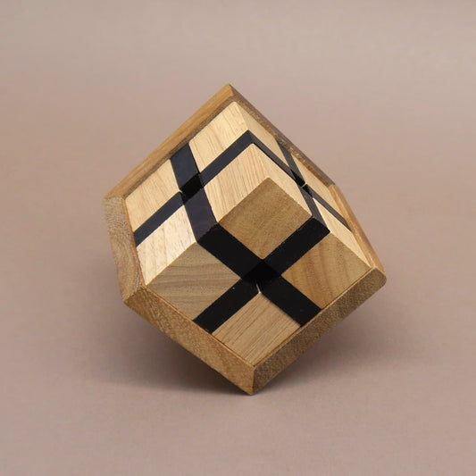 Holz denkspiel: ein hellbrauner Würfel mit schwarzen Streifen balanciert diagonal auf einer Ecke vor neutralem Hintergrund