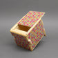 Teilgeöffnete Schatzkiste aus Holz mit aufwendigem geometrischen Design, zeigt die innere Kammer eines logischen Puzzles.