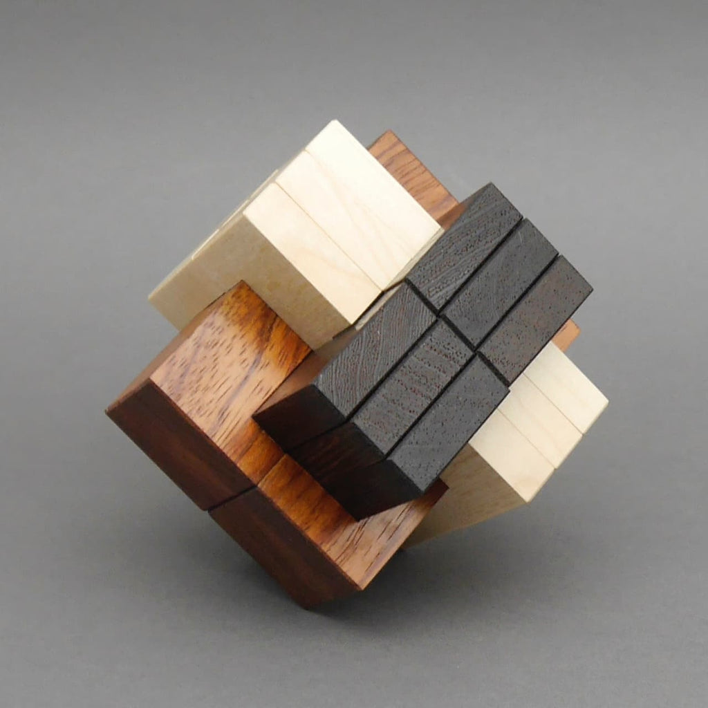 Mehrfarbiges, asymmetrisches Holzpuzzle aus mehreren ineinandergreifenden Holzklötzen vor neutralem Hintergrund.