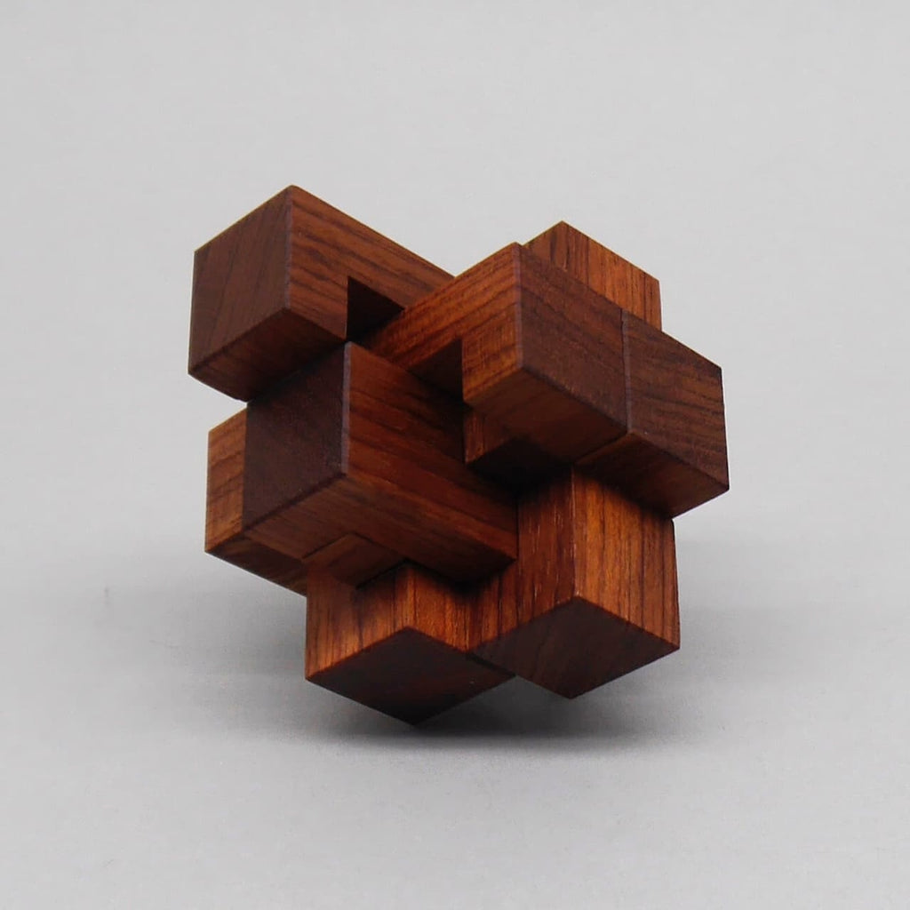 Komplexes 3D-Holzpuzzle aus ineinander verschachtelten dunklen Holzstäben auf hellem Hintergrund.