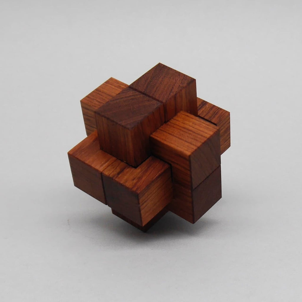 Verschachteltes Holzpuzzle in Würfelform mit mehreren ineinandergreifenden Elementen aus poliertem Holz.