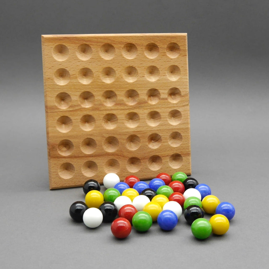 Paletto Brettspiel: leeres Holzbrett mit Vertiefungen und bunten Murmeln im Vordergrund.