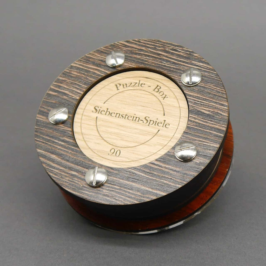 Handgefertigte Holzbox in warmer Maserung, die als kniffliges Geduldsspiel und originelle Geschenkverpackung dient.