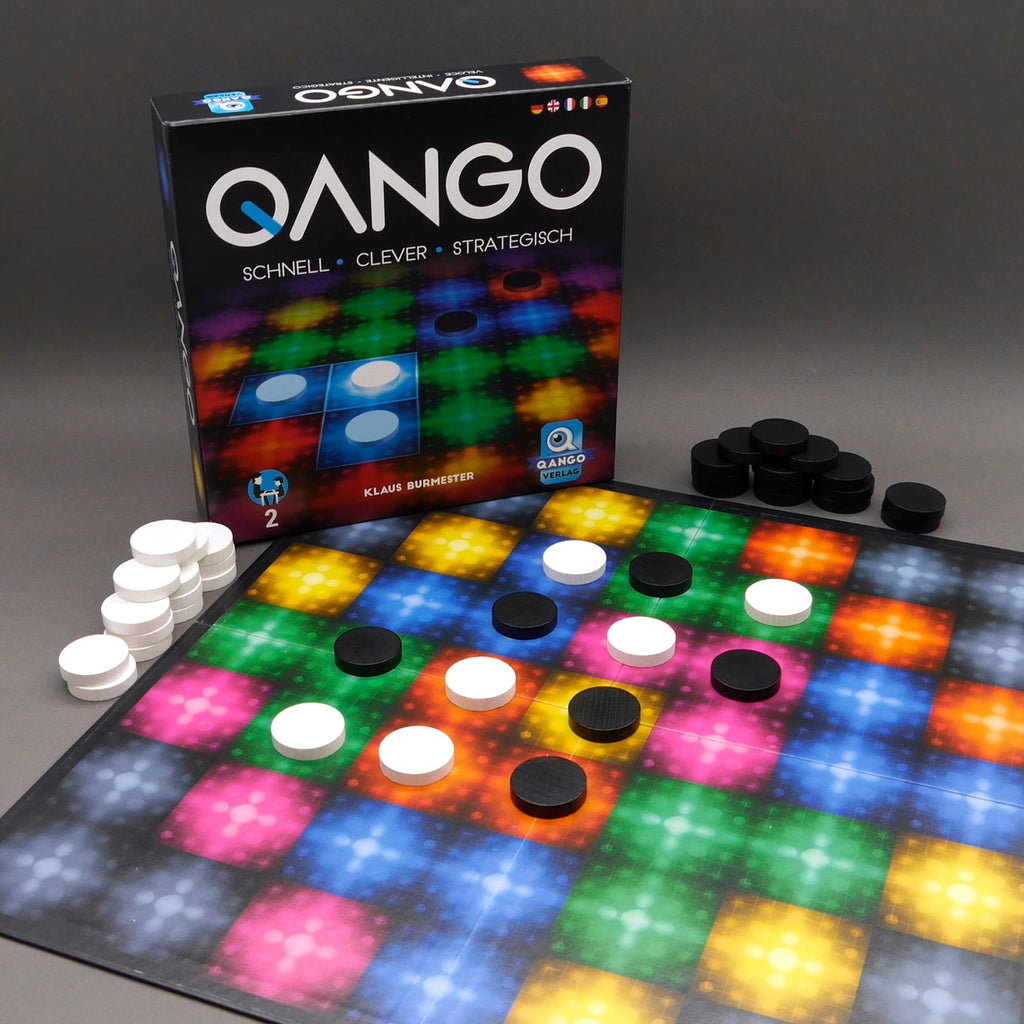 Qango Legespiel mit schwarzen und weißen Steinen auf farbigem Spielfeld als strategisches Denkspiel.