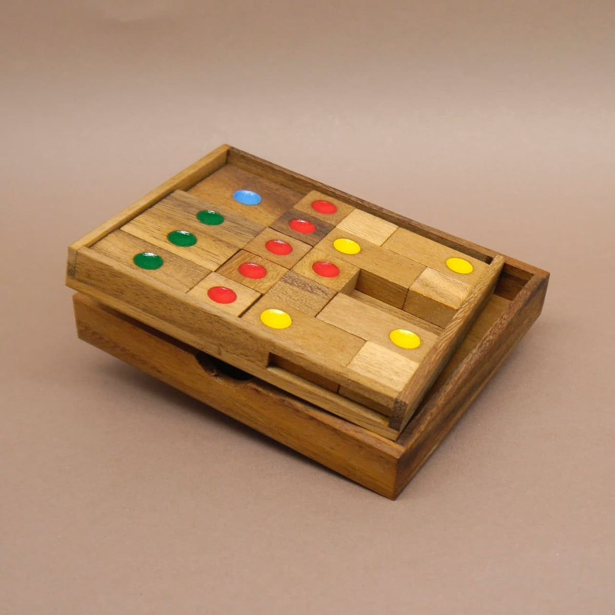 Holzspiel mit bunten Punkten, halb geöffnet in einer Holzkiste – ein klassisches Woodenpuzzle für knobelbegeisterte Spieler.