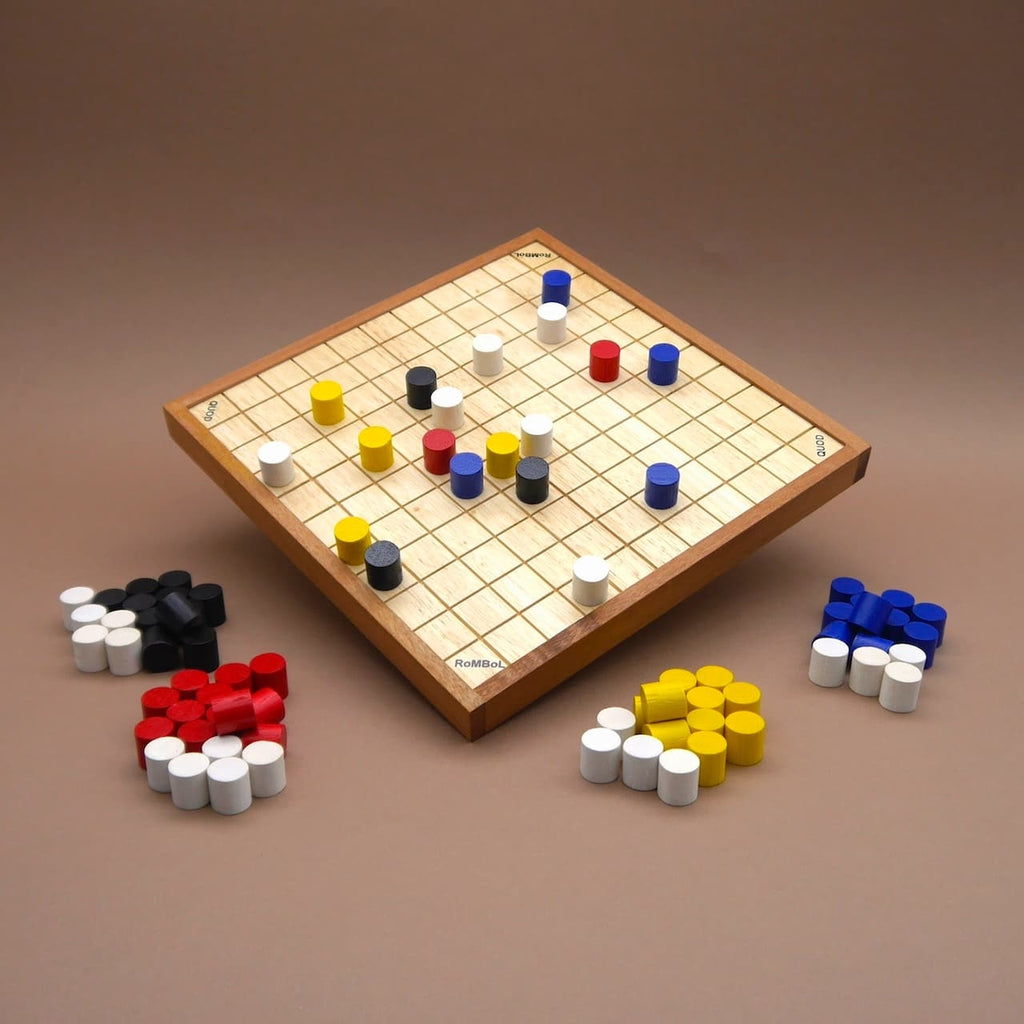 Quod Brettspiel auf massivem Holzbrett mit Raster; bunte Zylindersteine in Rot, Gelb, Blau, Weiß und Schwarz in aktiver Spielsituation.