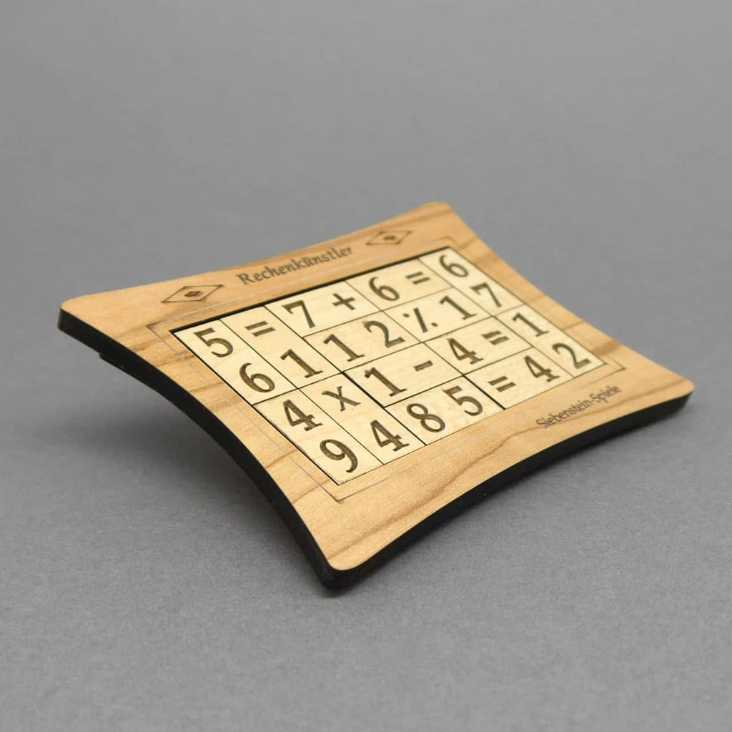 Mehrere unterschiedlich geformte Puzzleteile mit Zahlen und Symbolen liegen auf einer Fläche, die zu einem logischen Rechenpuzzle zusammengesetzt werden können.