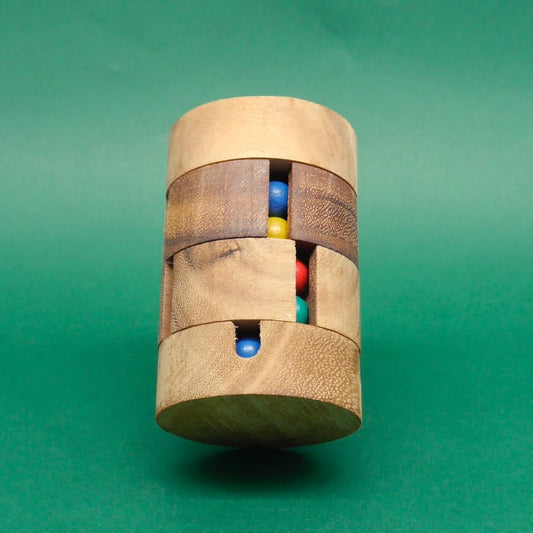 Aufrecht balancierendes Holz-Farbpuzzle mit vertikalen Spalten, die mehrere farbige Kugeln zeigen, vor monochrom grünem Hintergrund.