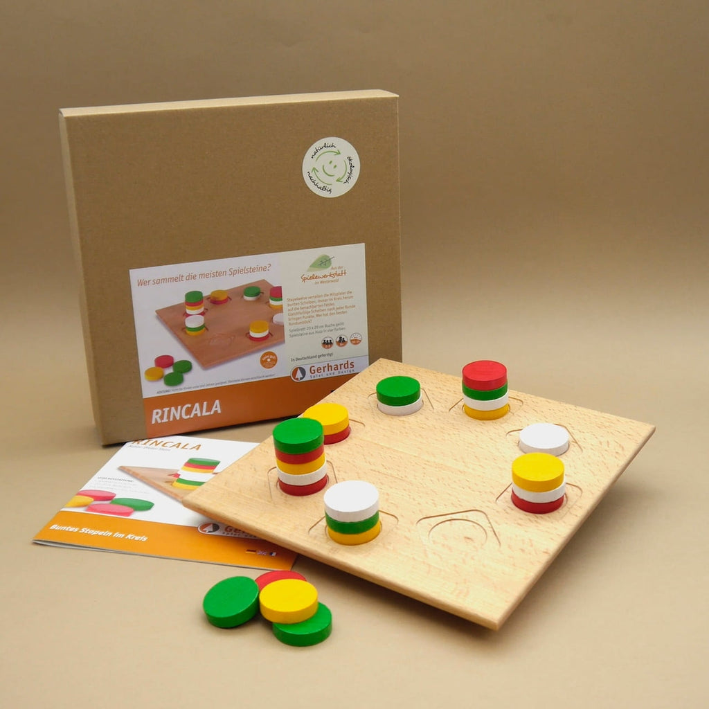 Rincala Taktikspiel: Holzbrett mit farbigen Scheiben neben Verpackung und Anleitung – Gesellschaftsspiel für gemeinsame Runden.