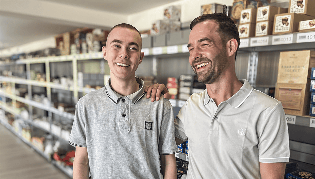 Inhaber von ROMBOL Denkspiele mit seinem Sohn vor einem Regal mit Knobelspiele