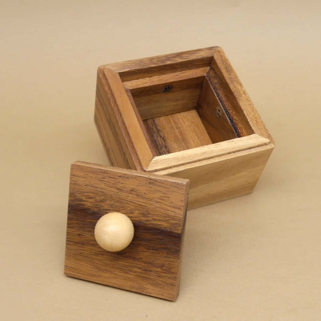 Offene Trickkiste aus Holz: Deckel mit Knauf abgenommen, leerer Innenraum deutlich sichtbar.