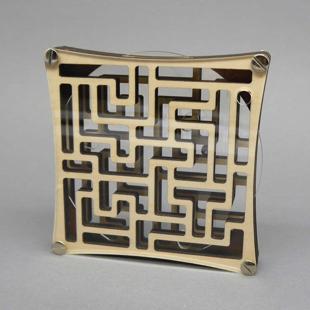 Frontalansicht eines quadratischen Kugellabyrinths aus Holz und Acryl; im Zentrum des hellen Gitters ist eine kleine Stahlkugel erkennbar.