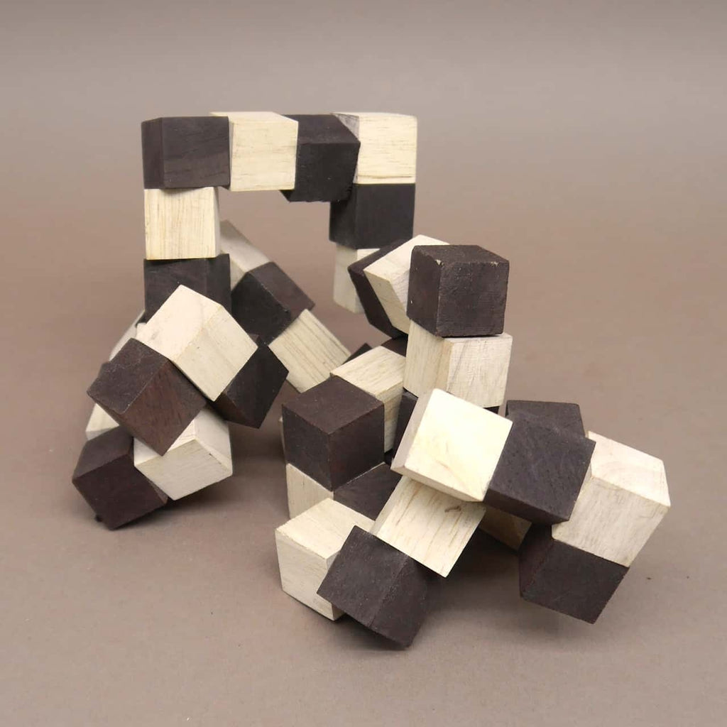Teilweise entwirrtes 3dpuzzle aus abwechselnd hellen und dunklen Holzwürfeln, die sich in einer geschwungenen Form auf grauem Hintergrund winden.