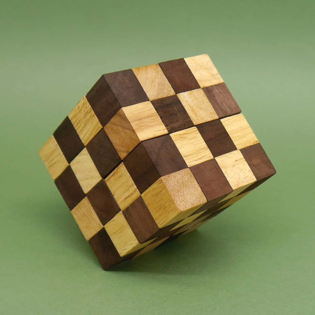 Schlangenwürfel 3D-Puzzle aus hell- und dunkelbraunen Holzwürfeln, leicht verdreht balancierend vor grünem Hintergrund.