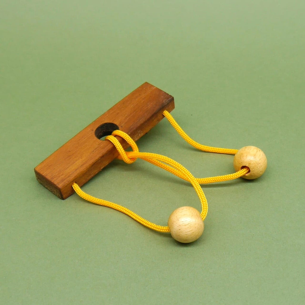 Holz-Schlaufenpuzzle mit gelbem Seil und Kugeln – ein kniffliges Seilrätsel für Freunde von Denkspielen.
