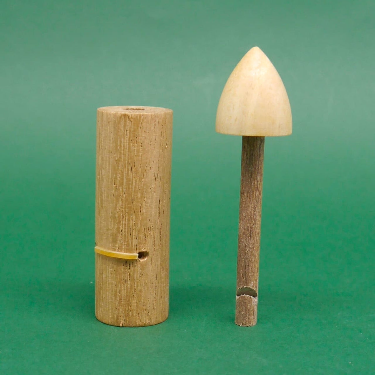 Holz‑Schnapper Trick, Magie‑Holzspiel / Partyspiel: Zylinder und Stab mit abgenommener konischer Kappe stehen aufrecht nebeneinander vor grünem Hintergrund.