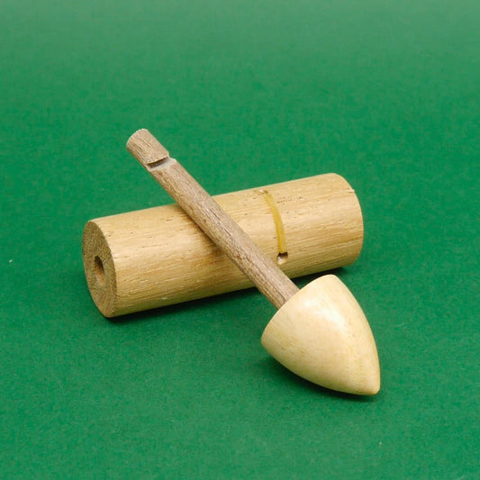 Holz‑Schnapper Zaubertrick‑Trickspiel, Geduldspiel: auseinandergenommenes Geschicklichkeitsspiel, Stab mit Spitze diagonal über liegendem Zylinder auf grünem Untergrund.