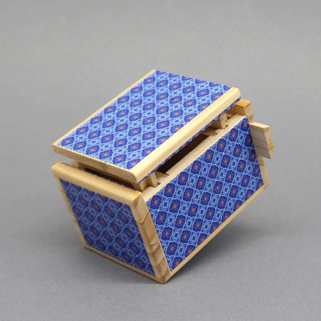 Holzbox Kyoto mit blauem Mosaikmuster, helle Kanten; Deckel halb geöffnet und Schiebeteile sichtbar, Studioaufnahme.