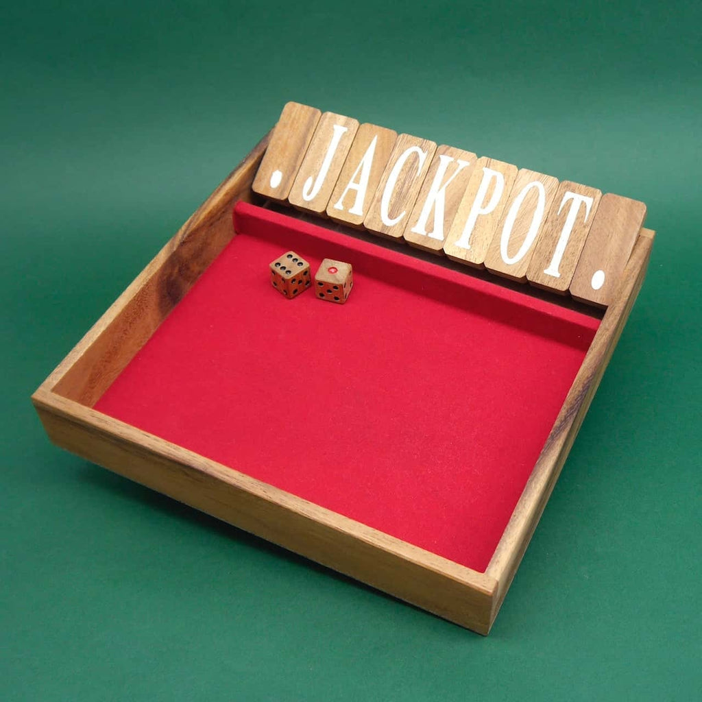 Ein Holzwürfelspiel namens "Shut the Box" mit einer roten Spielfläche, zwei Würfeln und Klappdeckeln mit der Aufschrift "JACKPOT". Das Spiel ist in einer dekorativen Holzbox auf grünem Hintergrund präsentiert.