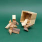 Geduldsspiel SixT: Holz-Packing-Puzzle mit geöffnetem Würfel und verstreuten, geometrischen Teilen.