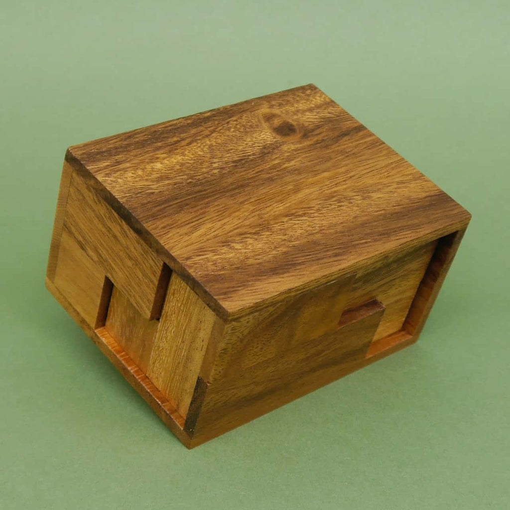 Zerlegtes Soma-Puzzle aus Holz vor einer rechteckigen Box, ideal für Geduldsspiele und Denkaufgaben.