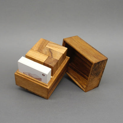 Geöffnete Holzbox mit 3D-Holzpuzzle und Karten, ein klassisches Knobelspiel aus Holz.