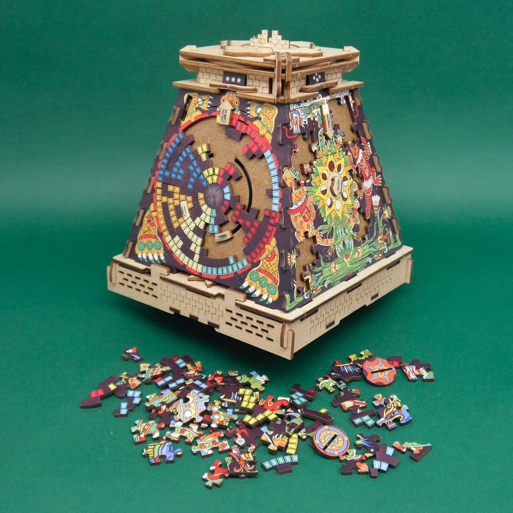 ztekische Pyramide Puzzle mit farbigen Glyphen und Drehscheiben; Holzgehäuse, verstreute Puzzleteile im Vordergrund.