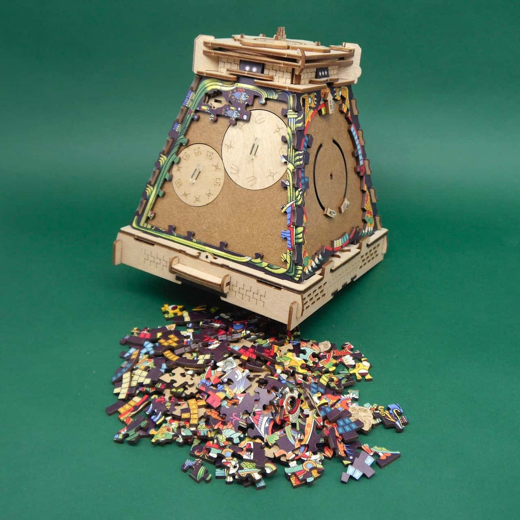 Holzpuzzle Aztekische Pyramide von hinten mit runden Einstell-Scheiben; viele bunte Teilchen liegen davor auf Grün.
