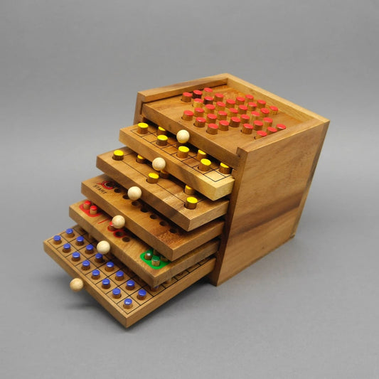 Offene Holzbox mit ausgezogenen Brettspiel-Schubladen und bunten Stecksteinen – vielseitige Holzspiele für knobelige Runden.