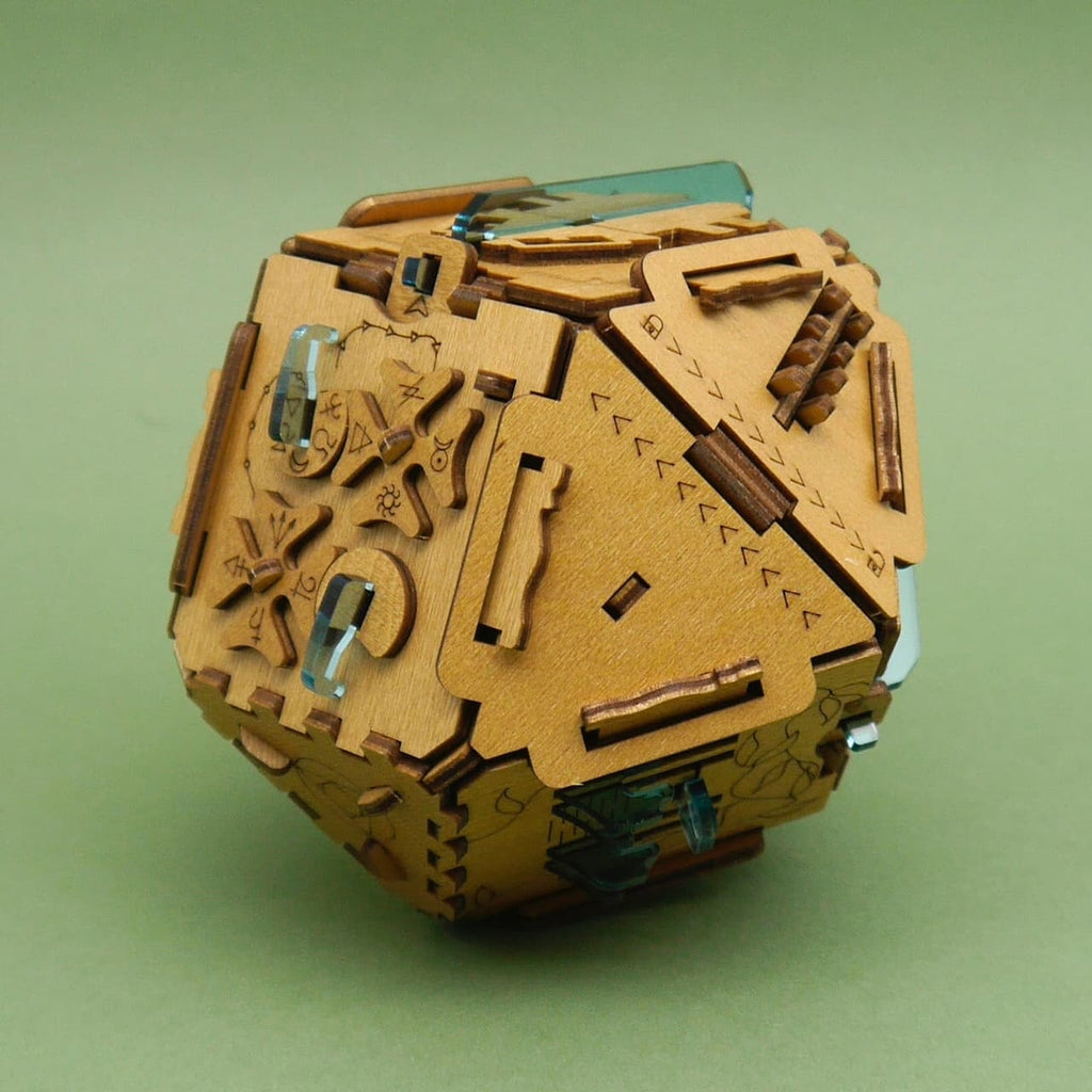 Holzpuzzle Stein der Weisen: detailreiche, mechanische Holzspiel-Kugel mit türkisfarbenen Inlays vor grünem Hintergrund.