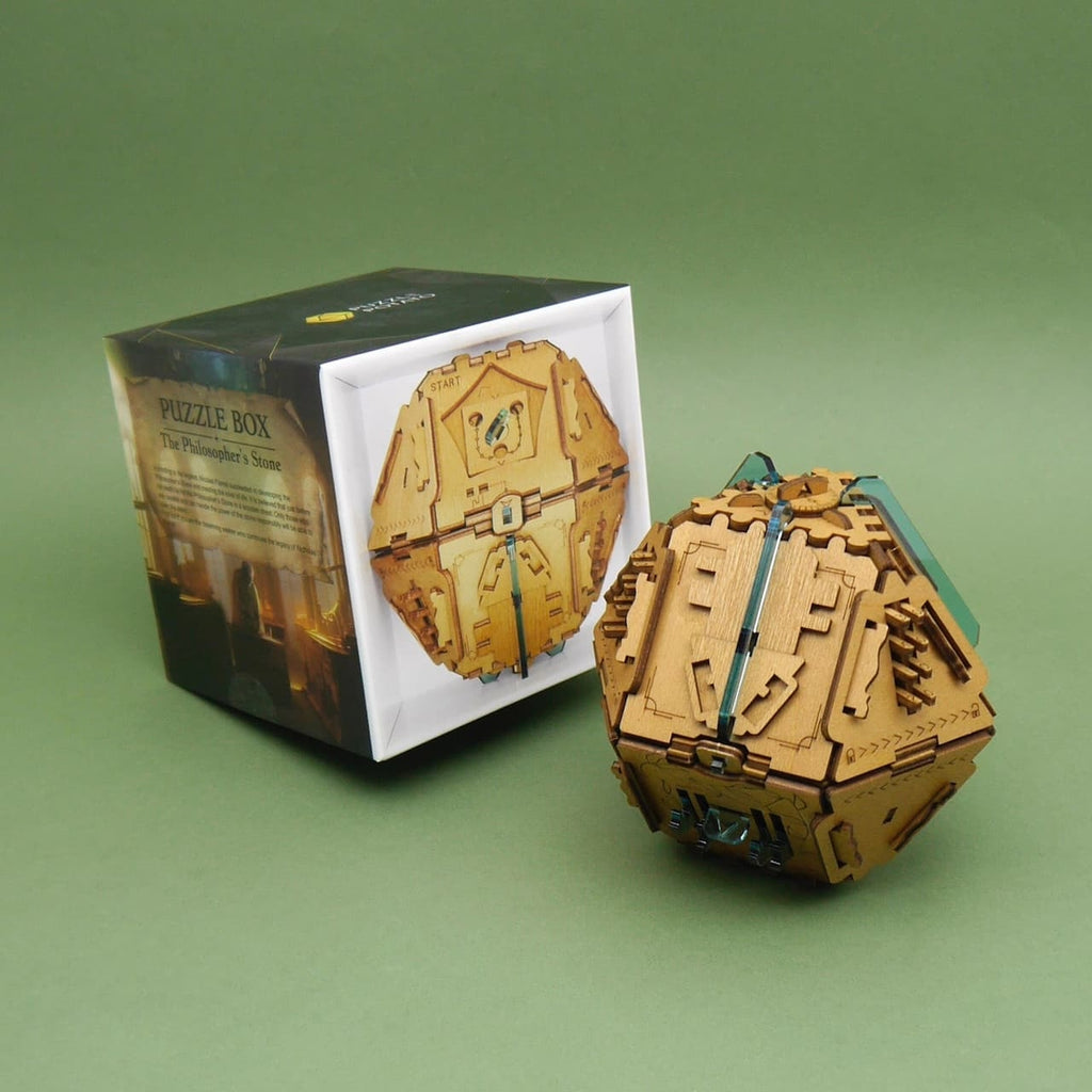 Cluebox Stein der Weisen als Denkspiel: hölzerne Puzzlebox mit Mechaniken und verborgenem Geheimfach, neben der Produktverpackung.