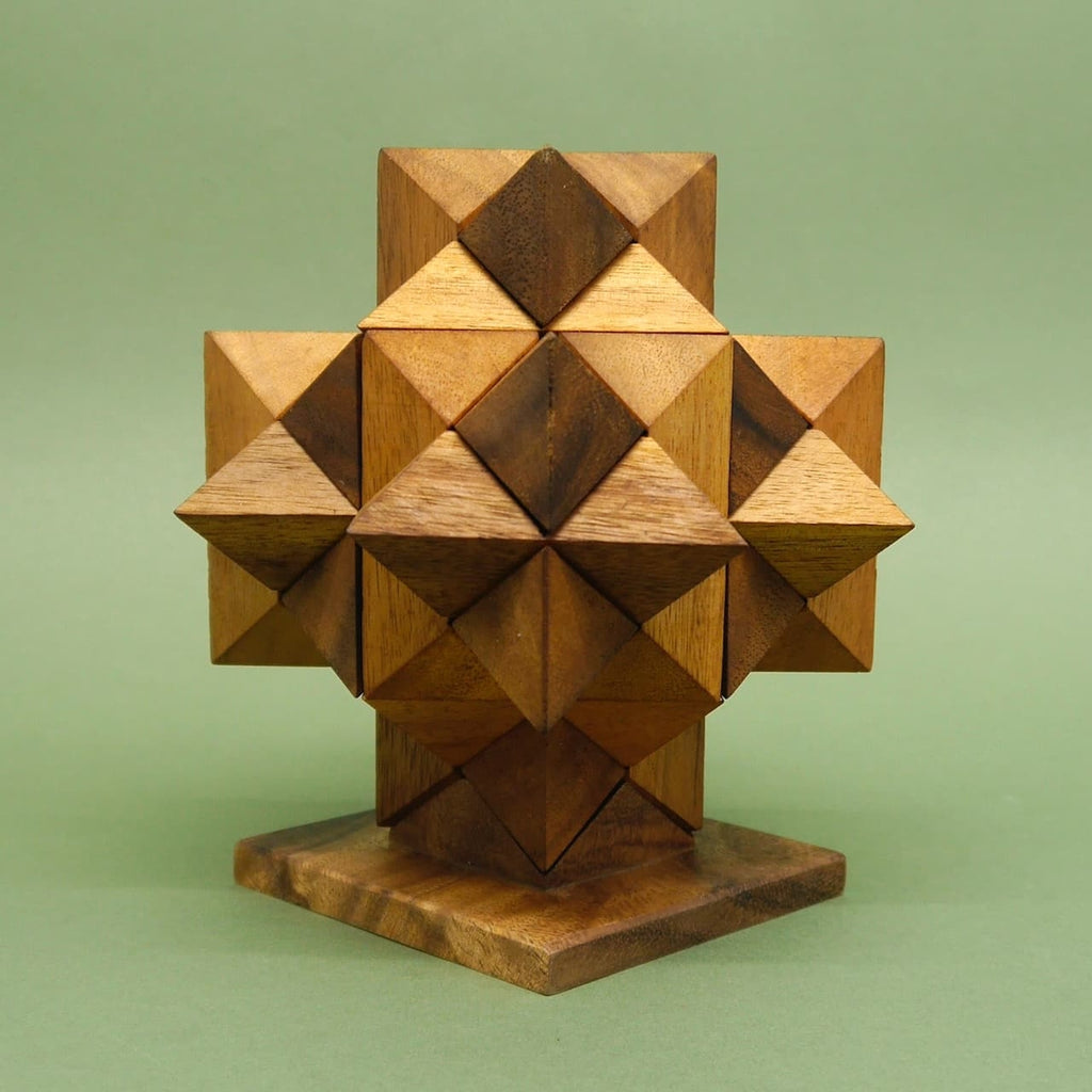 Geduldsspiel: Ein komplett zusammengesetztes Sternpuzzle bildet ein geometrisches Holz­kreuz auf einem quadratischen Sockel.