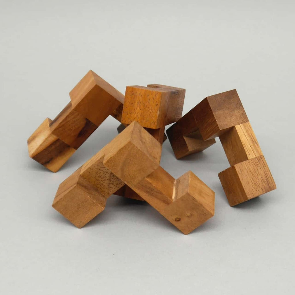 Unregelmäßig verschachtelte, massive Holzklötze bilden ein herausforderndes Knobelspiel in 3-D.