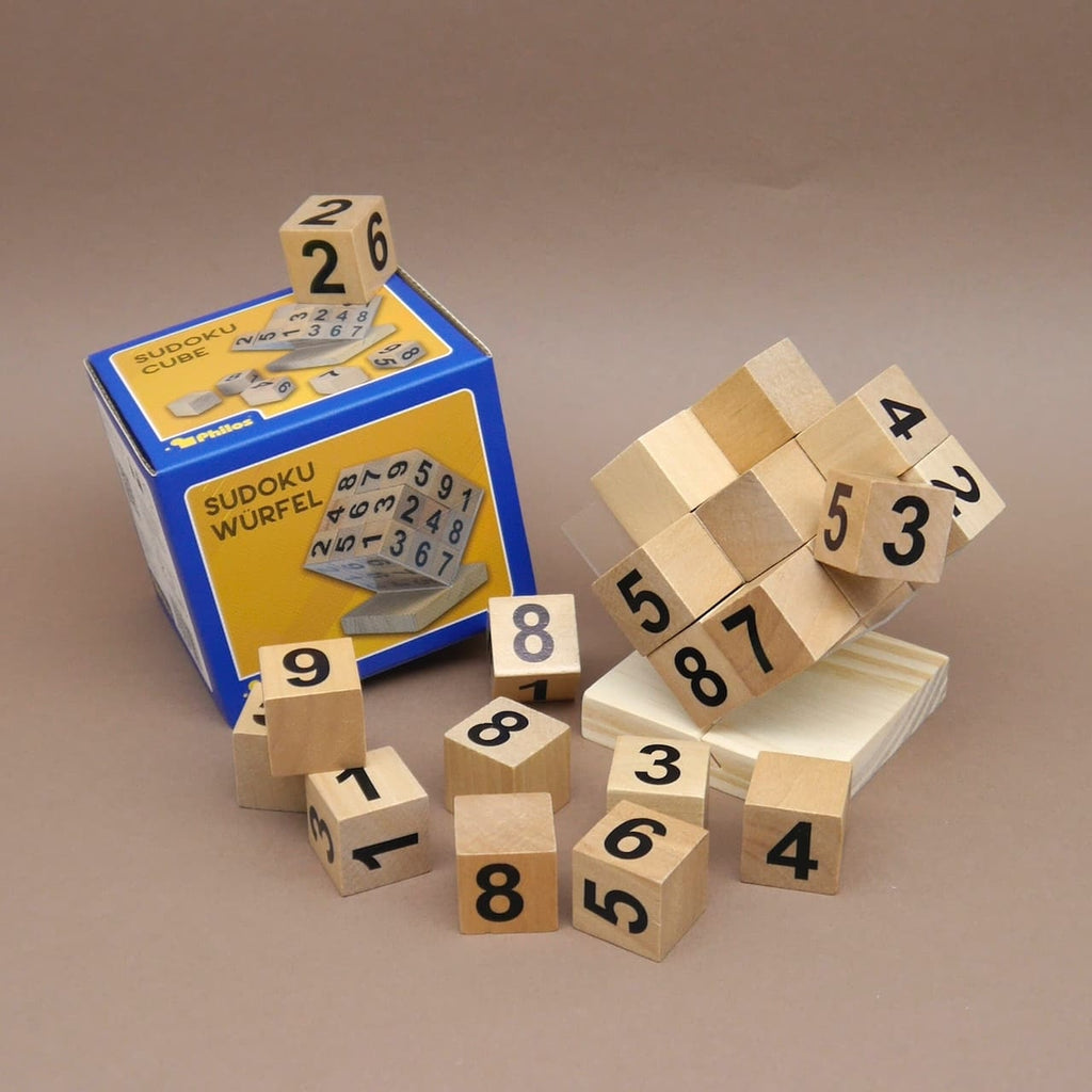 Sudoku Knobelwürfel aus Holz mit Zahlencubes vor der Verpackung aufgebaut, Teile liegen daneben als Puzzle.