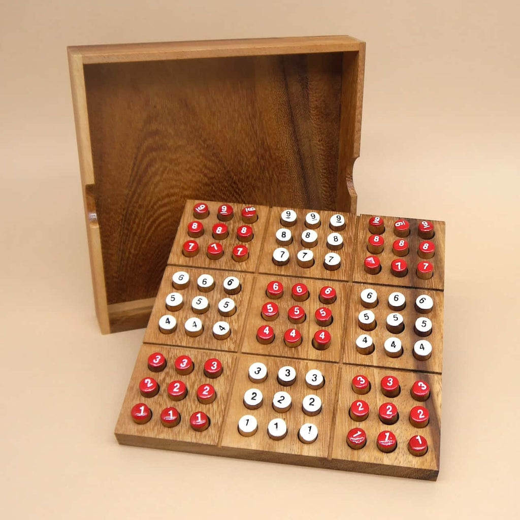 Offener Holzrahmen mit Sudoku holzspiel: quadratisches Spielfeld, rote und weiße Zahlenstecker stecken sortiert in neun Blöcken.
