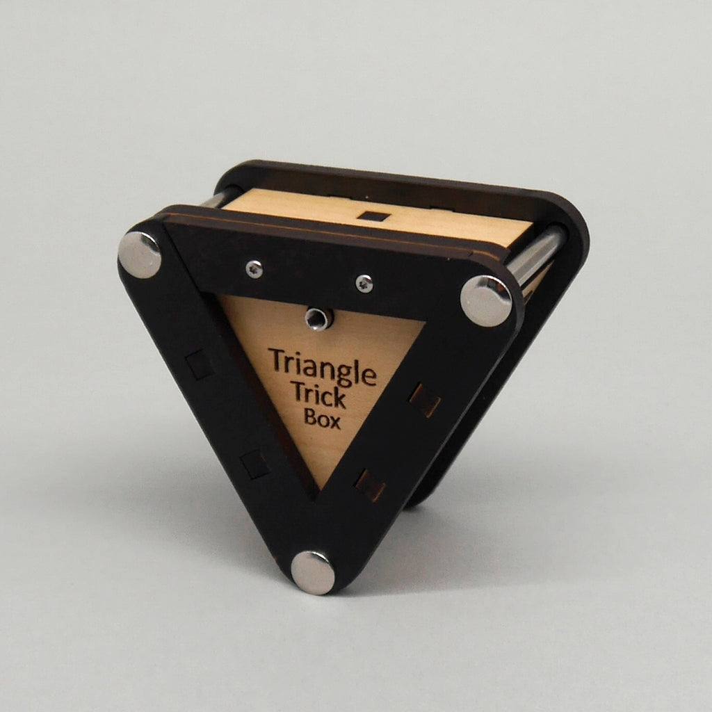 Dreieckige Holz-Trickbox als Denk- und Geduldsspiel, mit klar sichtbaren, ineinander passenden Holzelementen auf einer ebenen Oberfläche.