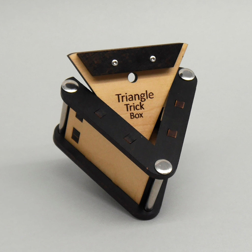 Geöffnete dreieckige Holz-Puzzlebox mit geheimem Fach, das an eine kleine Schatztruhe erinnert, präsentiert auf einem hellen Hintergrund.
