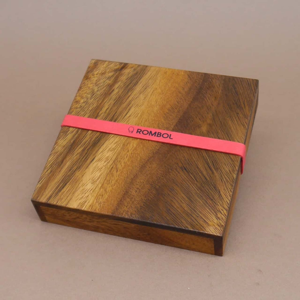 Quadratische Holzbox mit Tangram-Elementen, ideal als Geduldsspiel zur Förderung der Konzentration.