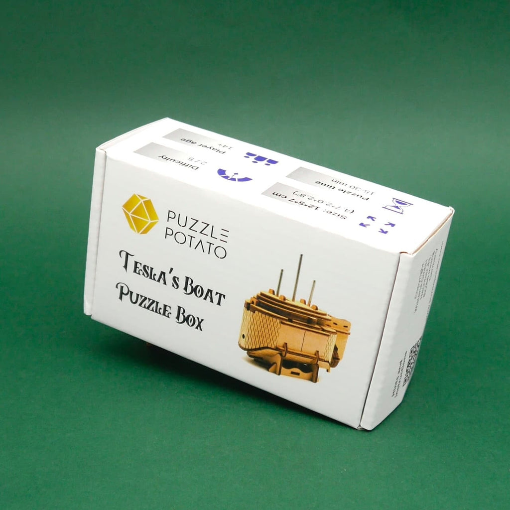 Cluebox Tesla’s Boat: weiße Produktverpackung mit Bild der Holzpuzzle-Box auf grünem Hintergrund.