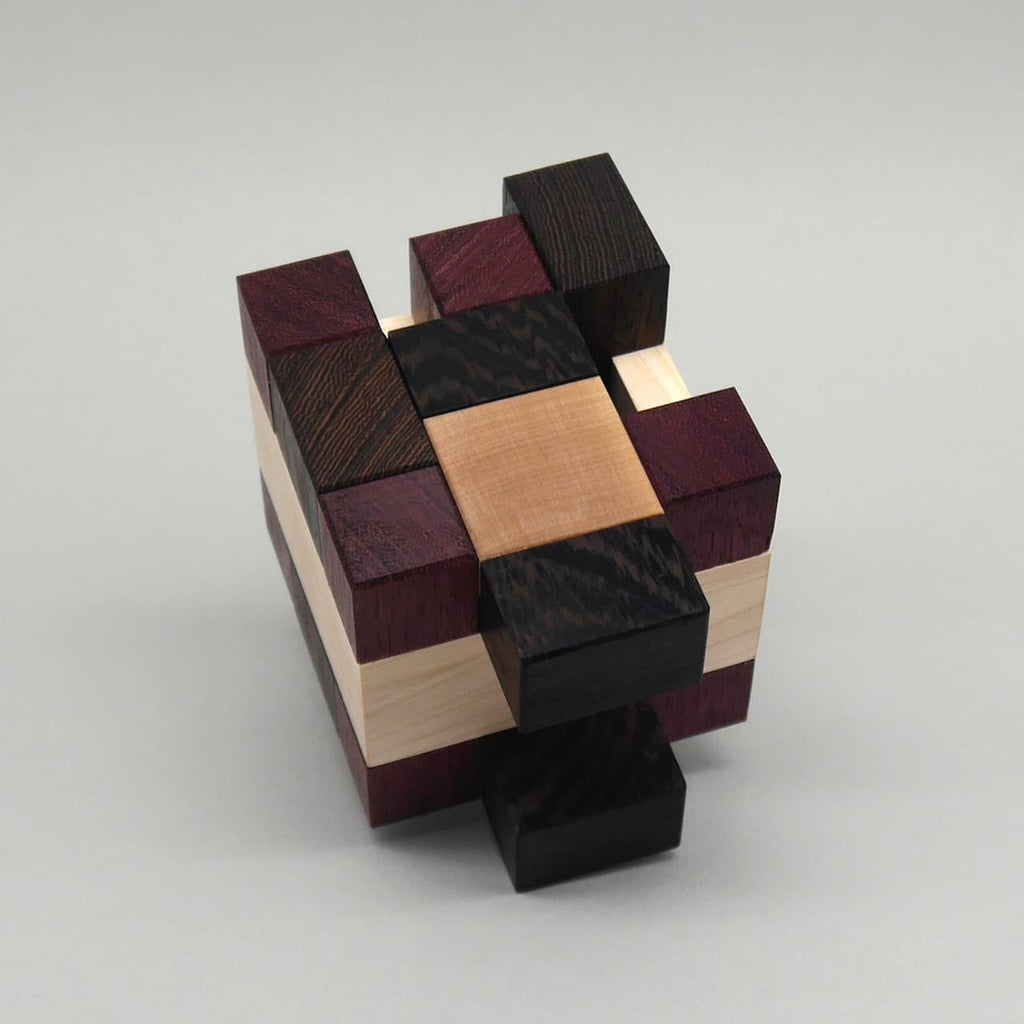 Geduldsspiel aus ineinandergreifenden Holzblöcken, ein interlocking Puzzle mit verschiedenen dunklen und hellen Hölzern.
