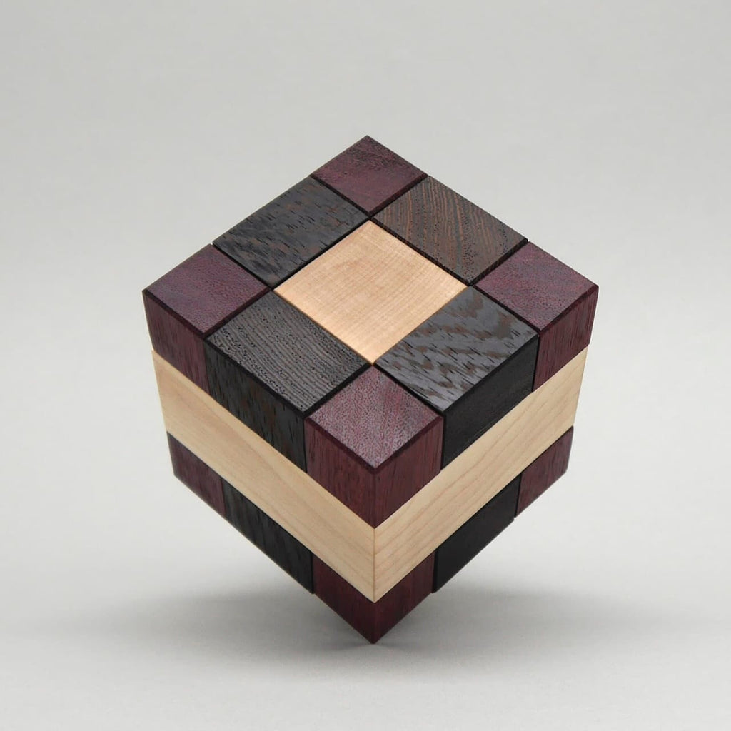 Holzwürfel Denkspiel aus mehreren farblich unterschiedlichen Holzarten, zusammengesetzt als präzises Wooden Puzzle.